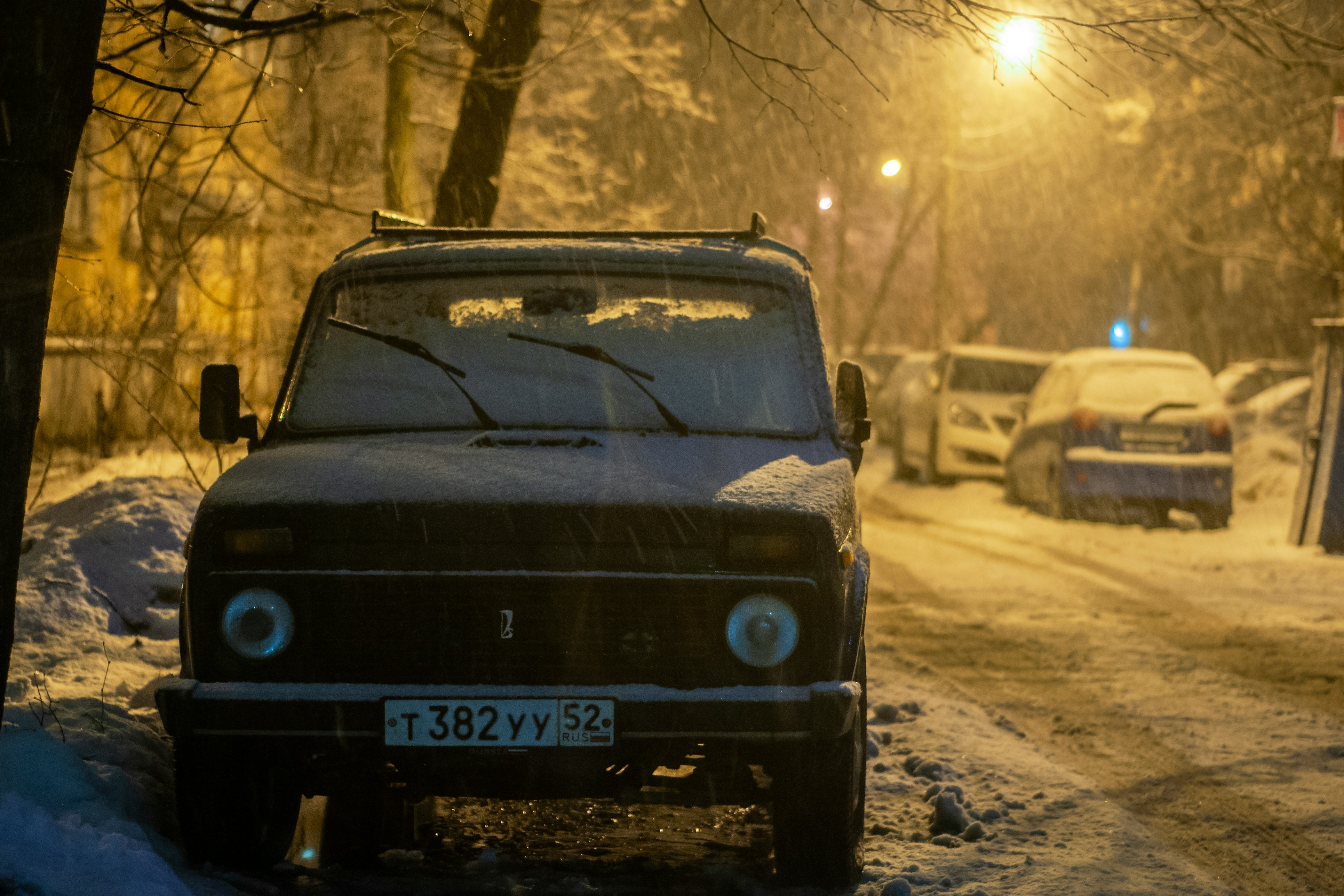 a lada niva parked with snow on it
